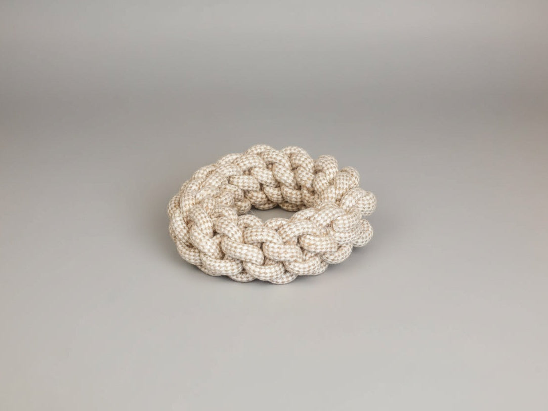 A super thick hemp rope toy in a braided ring shape, placed on a wooden surface.